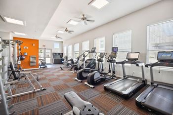 A gym with treadmills, elliptical machines, and other exercise equipment at 45 Madison Apartments, Kansas City, 64111